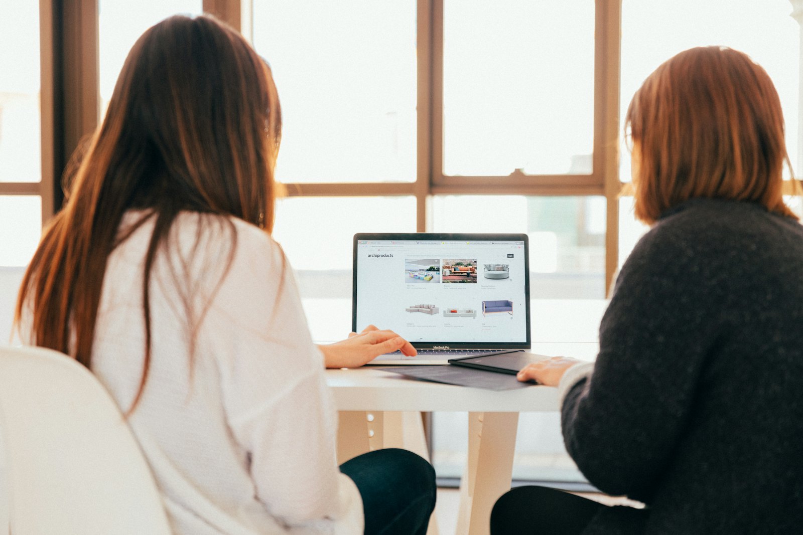 Zwei Menschen arbeiten gemeinsam am Laptop